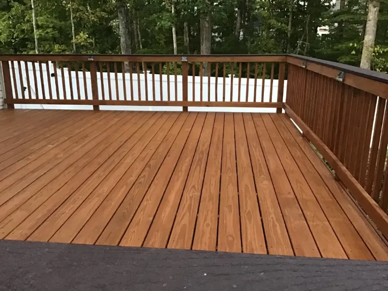 Wooden deck with brown rails overlooking trees