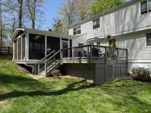 image shows the exterior of a house featuring a screened porch and a deck