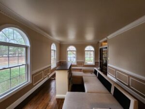 image shows the interior of a room featuring a built-in seating area with light-colored cushions and a dark backrest